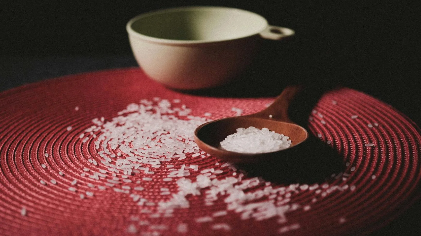 brown wooden spoon with grains on red table cloth